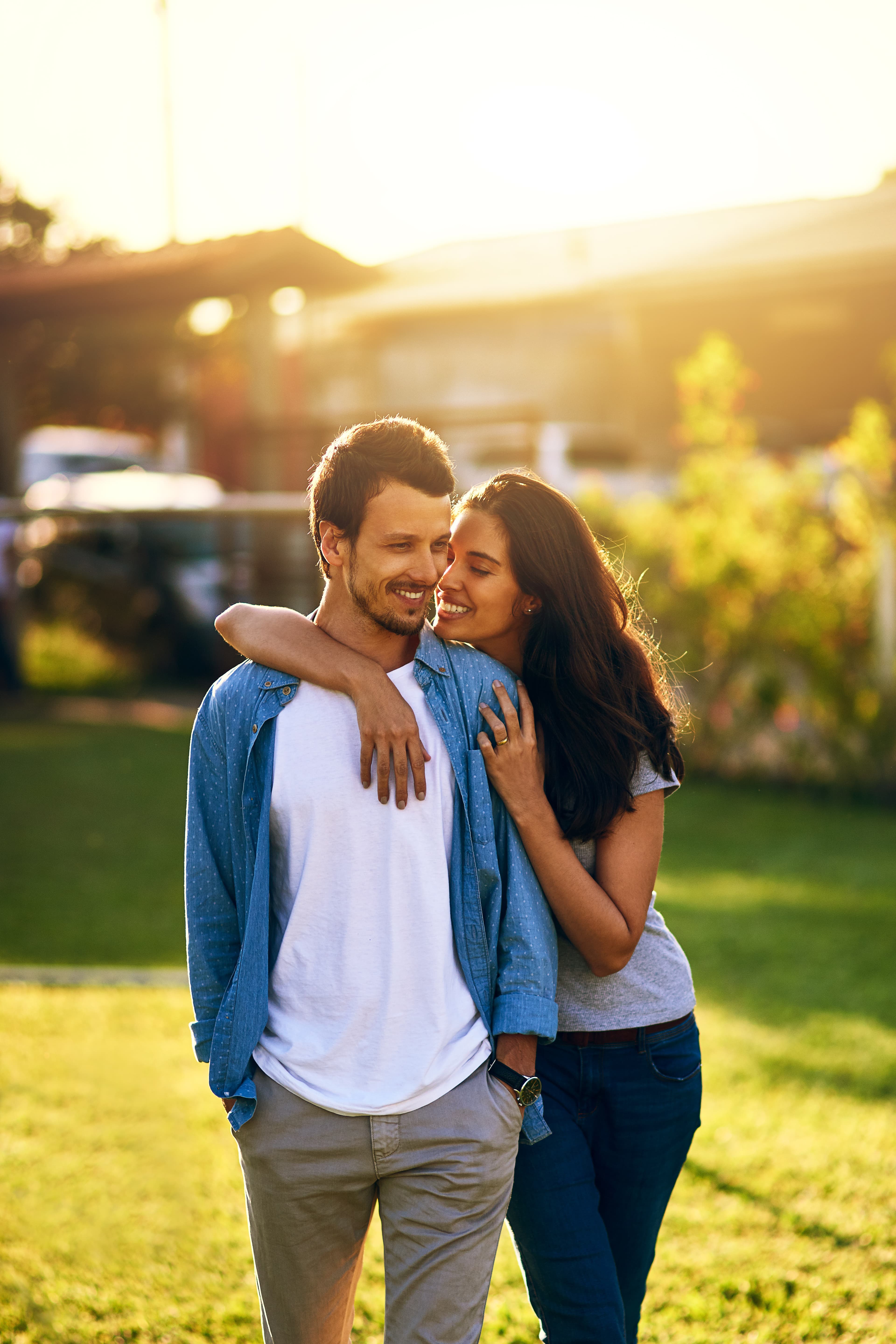 La pareja abrazada al atardecer en un jardín